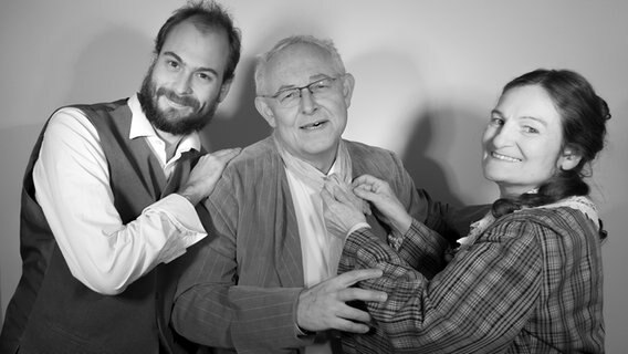 Die Figuren (v.l.n.r.) Dick Wilkens (Lucas Kade), Mr. Fezziwig (Erhard Kühnle) und Mrs. Fezziwig (Blandine Dufour) posieren für ein schwarz-weiß Bild. © Marni Hanke Foto: Marni Hanke