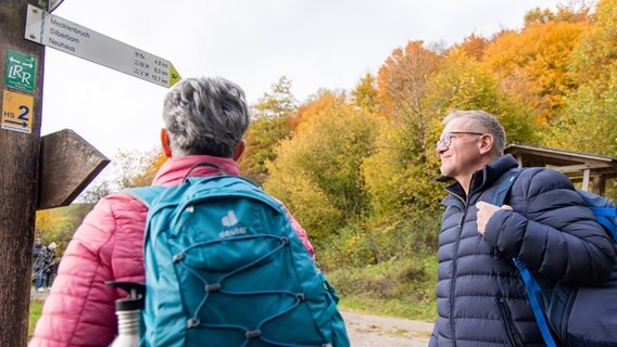 Zwei Wanderer schauen auf Wegmarkierungen im Naturpark Solling-Vogler. © Solling-Vogler-Region im Weserbergland e. V. 