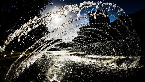 Wasser sprudelt im Gegenlicht aus einer Brunnenanlage. © dpa-Bildfunk Foto: Swen Pförtner