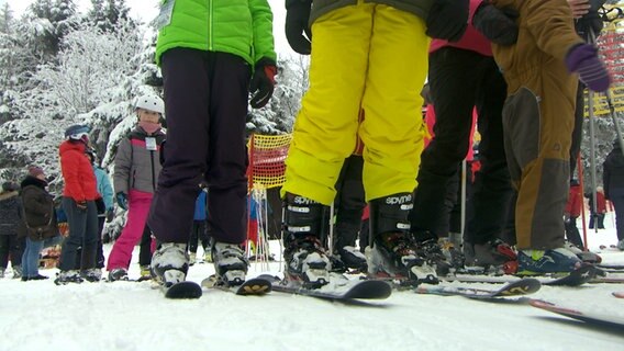 Wintersportler stehen vor einem Skilift an. © NDR 