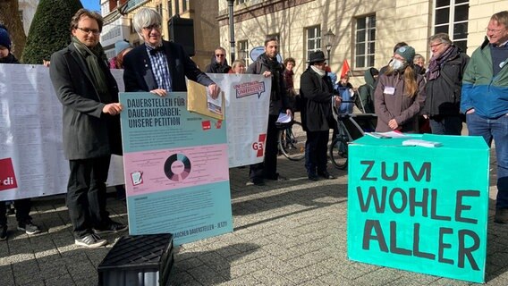 Bei einer Demo zu Tarifverträgen für Uni-Beschäftigte in Göttingen stehen Universitätspräsident Metin Tolan (rechts) und Simon Sendler, Softwareentwickler an der Unibibliothek, nebeneinander und halten ein Plakat. © NDR Foto: Bärbel Wiethoff