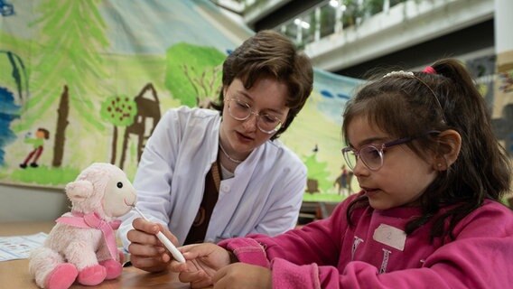 Ein Kind aus der Kindertagesstätte Weende-Nord lässt im Teddybär-Krankenhaus am Uniklinikum Göttingen Fieber an ihrem Plüschtier messen. © Swen Pförtner/dpa Foto: Swen Pförtner
