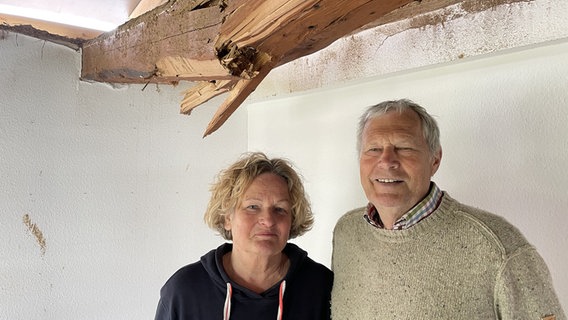 Eleonore Engell-Clauditz und Rolf Clauditz stehen unter einem geborstenen Balken und lächeln in die Kamera. © NDR Foto: Michael Brandt