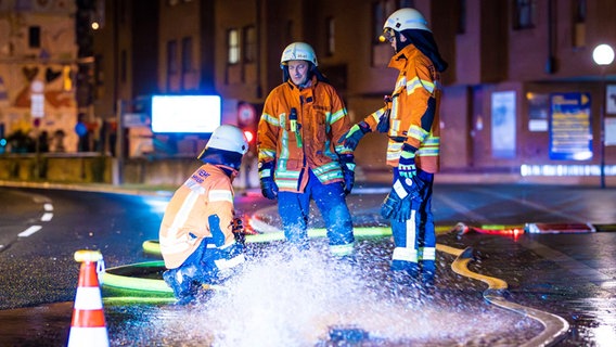 Einsatzkräfte der Feuerwehr Braunschweig pumpen in der Nacht Regenwasser aus einem Keller auf die Straße © picture alliance/dpa | Moritz Frankenberg Foto: Moritz Frankenberg