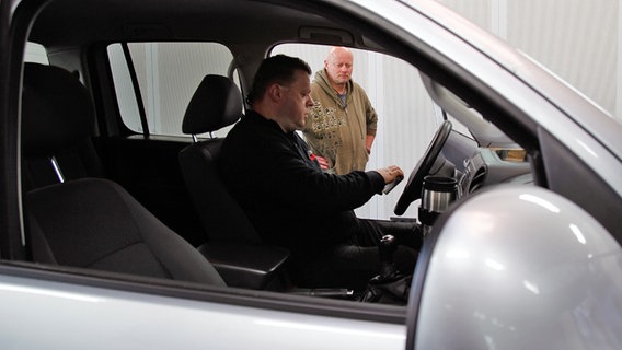 Ein Techniker vom Rollenprüfstand sitzt in dem VW Amarok des VW-Kunden Stefan Ader. © NDR Foto: Björn Siebke