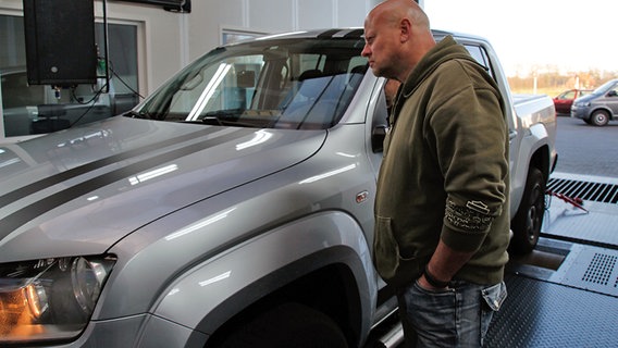 Der VW-Kunde Stefan Ader steht neben seinem VW Amarok. © NDR Foto: Björn Siebke