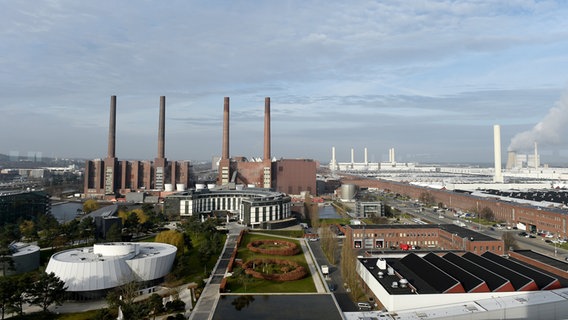 Das VW-Kraftwerk steht mit seinen vier markanten Schornsteinen neben dem Werksgelände und einigen Gebäuden der Autostadt in Wolfsburg. © dpa-Bildfunk Foto: Rainer Jensen