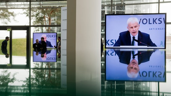 Volkswagen Vorstandsvorsitzender Matthias Müller ist auf einem Monitor zu sehen, der sich in einem Glastisch spiegelt. © dpa-Bildfunk Foto: Julian Stratenschulte