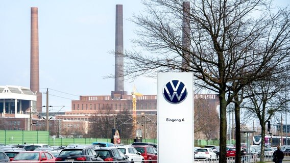 Das Logo der Volkswagen AG steht an der Einfahrt zu einem Mitarbeiterparkplatz vor dem Werk in Wolfsburg. © picture alliance/dpa Foto: Hauke-Christian Dittrich