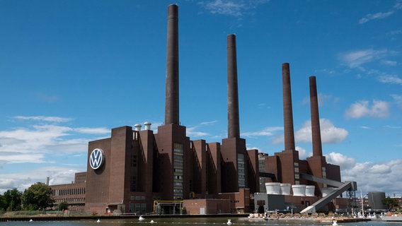 Das Kraftwerk der Volkswagen AG steht am Wasser unter einem blauen Himmel. © picture alliance/dpa Foto:  Melissa Erichsen