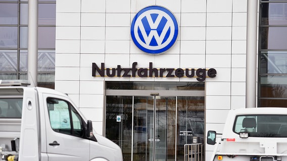 Vor dem Eingangsbereich zu VW-Gebäude stehen zwei Fahrzeuge. © picture-alliance 