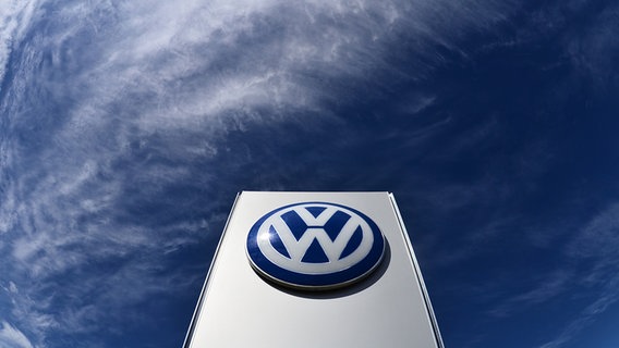 Das Volkswagen Logo ragt in einen dunklen Himmel. © dpa-Bildfunk Foto: Julian Stratenschulte