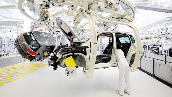 Ein Mitarbeiter der Volkswagen AG arbeitet im Volkswagenwerk in Wolfsburg an einer VW Tiguan-Karosse. © dpa-Bildfunk Foto: Jochen Lübke