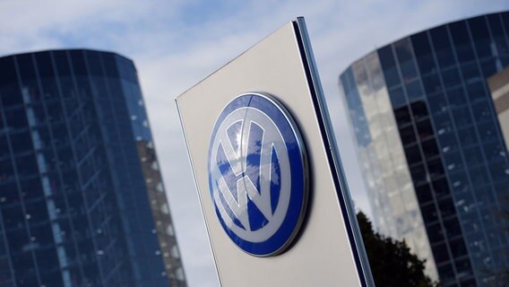 Das VW-Logo vor dem Hintergrund der Auslieferungstürme der Autostadt in Wolfsburg © dpa Bildfunk Foto: Rainer Jensen