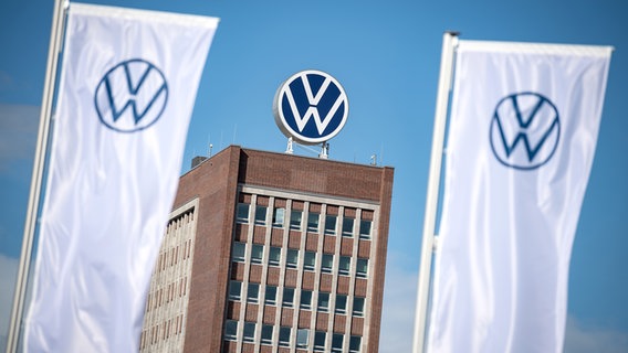 Vor dem Verwaltungshochhaus der Volkswagen AG wehen zwei Fahnen mit dem VW-Logo. © dpa - Bildfunk Foto: Sina Schuldt