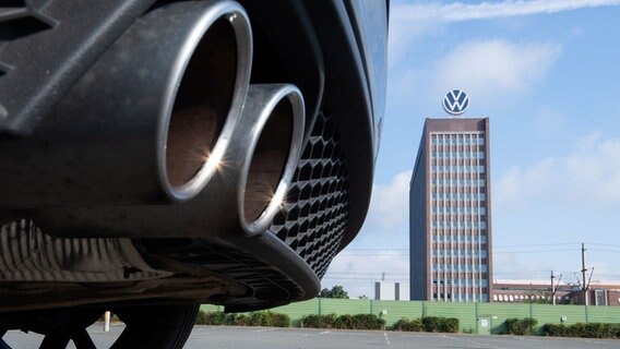 Auspuffrohre eines Volkswagen, fotografiert mit dem Markenhochhaus am VW Werk Wolfsburg am 11.08.2021. © dpa-Bildfunk Foto: Julian Stratenschulte