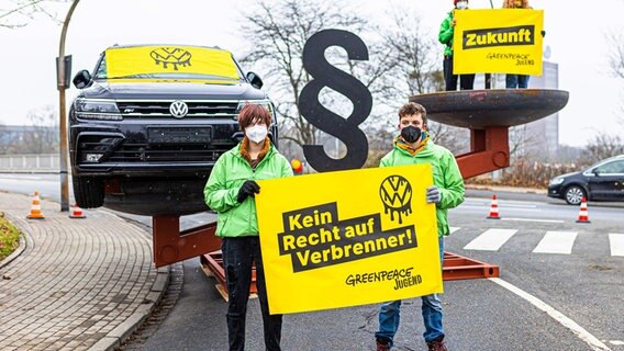 Aktivisten der Umweltschutzorganisation "Greenpeace" demonstrieren dafür, dem Schutz des Klimas mehr Gewicht zu geben. In einer überdimensionalen Waage ist auf der einen Seite ein Auto, auf der anderen Seite ein Schriftzug "Zukunft" zu sehen. © Moritz Frankenberg/dpa Foto: Moritz Frankenberg/dpa