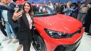 Daniela Cavallo, Vorsitzende des Gesamt- und Konzernbetriebsrats der Volkswagen AG, macht ein Selfie mit dem neuen Volkswagen Tiguan eHybrid im VW-Werk Wolfsburg. © dpa Bildfunk Foto: Julian Stratenschulte