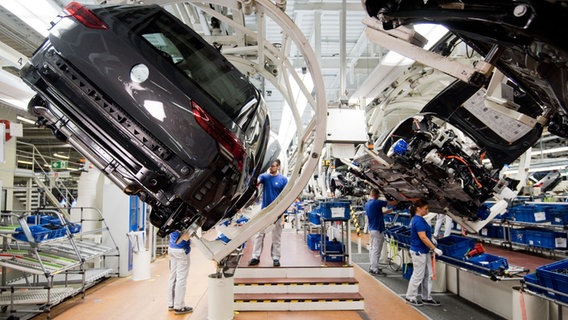 Ein neuer Volkswagen Golf 8 schwebt an einer Produktionslinie im VW Werk. © dpa / picture alliance Foto: Julian Stratenschulte