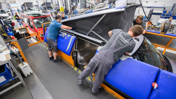 VW Mitarbeiter montieren das Dach von einem Reisemobil Volkswagen California. © picture alliance/dpa Foto: Julian Stratenschulte