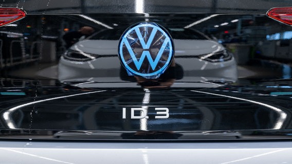 Im Lack eines ID.3-Modells von Volkswagen spiegelt sich das VW-Logo. © dpa - picture alliance Foto: Hendrik Schmidt