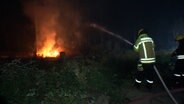 Eine Einsatzkraft der Feuerwehr löscht einen Brand im Wald. © TeleNewsNetwork 