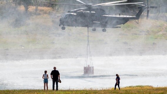 Ein Hubschrauber CH-53 der Bundeswehr entnimmt Wasser aus der Mandelholztalsperre zur Bekämpfung eines Waldbrandes. © dpa Foto: Melissa Erichsen