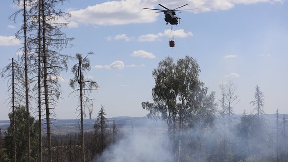 Ein Bundeswehr-Hubschrauber löscht einen Waldbrand im Harz. © dpa Foto: Matthias Bein