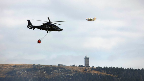 Ein Löschhubschrauber und ein italienisches Löschflugzeug bei der Bekämpfung eines Waldbrandes am Brocken. © dpa-Bildfunk Foto: Matthias Bein
