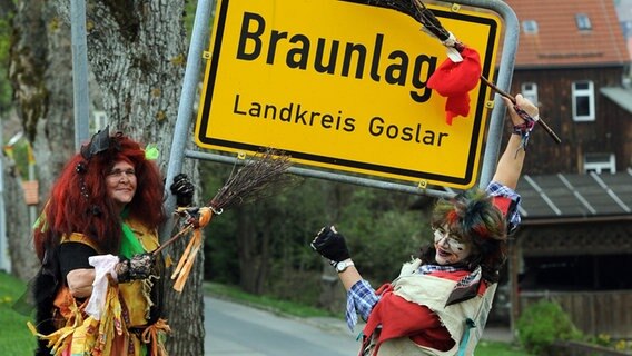 Zwei "Hexen" posieren in Braunlage vor dem Ortsschild. Zwei "Hexen" posieren in Braunlage vor dem Ortsschild. © dpa-Bildfunk Foto: Caroline Seidel