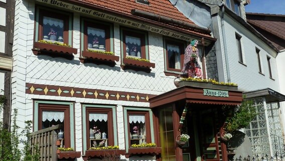 Auf dem Vordach eines Hauses im Harz sitzt eine Hexe. © NDR Foto: Tina Zemmrich