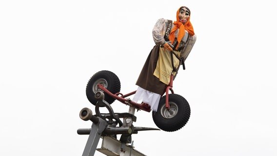 Eine Hexenfigur auf einem Roller ist an einer Straße installiert. © dpa-Bildfunk Foto: Swen Pförtner
