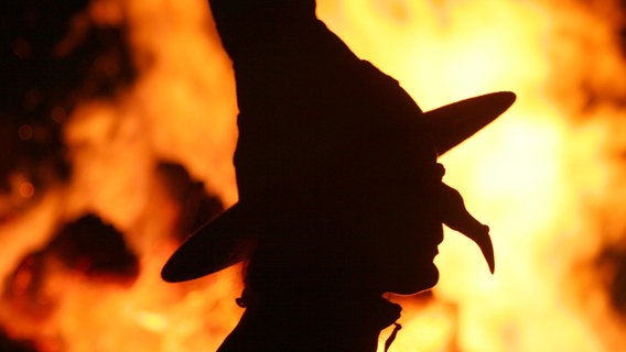 Sachsen-Anhalt, Schierke: Die Silhouette einer «Hexe» vor einem Feuer, aufgenommen während der Walpurgisnacht. © dpa-Bildfunk Foto: Matthias Bein
