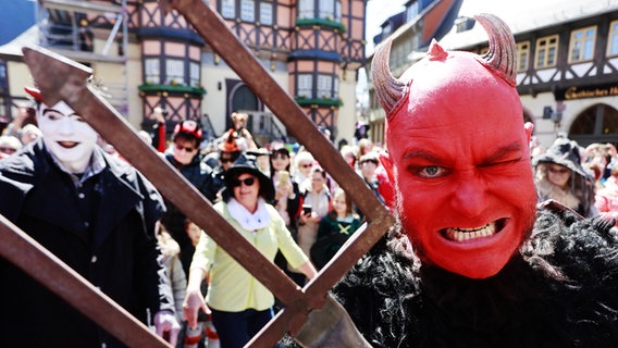 Ein als Teufel verkleideter Mann beim Walpurgisnacht-Umzug vor dem Rathaus in Wernigerode. © dpa-Bildfunk Foto: Matthias Bein