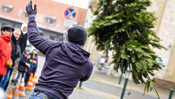 Ein Teilnehmer wirft beim Weihnachtsbaumweitwurf auf dem Welfenplatz einen Weihnachtsbaum © picture alliance/dpa/Moritz Frankenberg Foto: Moritz Frankenberg