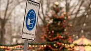 Ein Schild auf einem Weihnachtsmarkt weißt auf die Maskenpflicht hin. © dpa-Bildfunk Foto: Swen Pförtner
