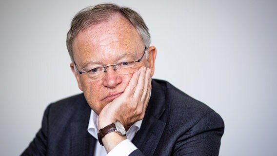 Stephan Weil (SPD) sitzt an einem Tisch und stützt seinen Kopf mit der Hand ab. © picture alliance/dpa Foto: Moritz Frankenberg