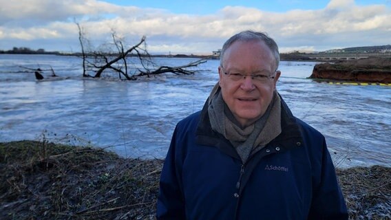 Stephan Weil (SPD) steht vor einem Überschwemmungsgebiet. © NDR Foto: Kevin Poweska