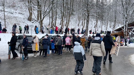 Wintersportler warten auf einem Parkplatz am Wurmberg in Braunlage. © NDR Foto: Lydia Callies