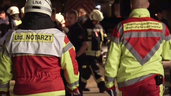 Ein Notarzt und Einsatzkräfte der Feuerwehr stehen vor einem Wohnhaus in Wolfsburg. © NonstopNews 