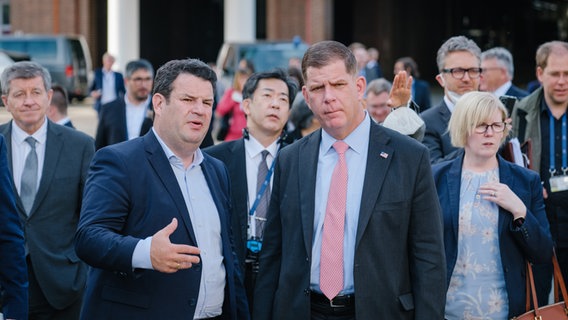 Hubertus Heil (SPD), Bundesarbeitsminister, spricht mit Marty Walsh, US-Arbeitsminister, während einer Werksführung der Delegation der G7 Arbeits- und Sozialminister bei Volkswagen. © dpa-Bildfunk Foto: Ole Spata/dpa