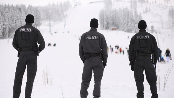 Einsatzkräfte der Polizei überwachen den Besucherstrom am Rodelhang am Wurmberg. © dpa/Matthias Bein Foto: Matthias Bein