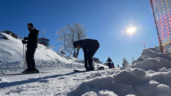 Skifahrende auf dem Wurmberg. Dahinter blauer Himmel und Sonne. © NDR Foto: Jan Fragel