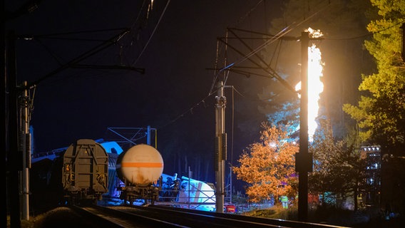 Leiferde: Beschädigte Waggons stehen und liegen auf dem Bahndamm, während Gas aus einem der Waggons kontrolliert abgefackelt wird. © dpa-Bildfunk Foto: Philipp Schulze