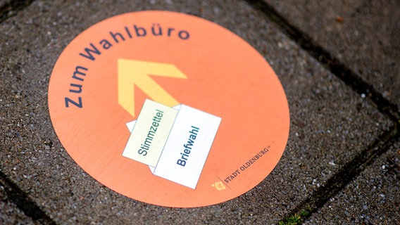 Ein auf den Boden aufgebrachter Aufkleber mit der Aufschrift ·zum Wahlbüro· weist vor einem Gebäude der Stadtverwaltung auf den Weg zum Wahlbüro hin. © dpa-Bildfunk Foto: Hauke-Christian Dittrich
