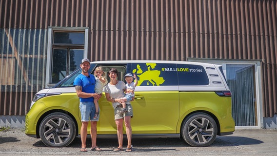 Eine kleine Familie steht vor einem Volkswagen ID.Buzz. © Volkswagen 