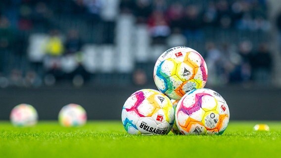 Bundesliga-Spielbälle liegen gestapelt auf einem Rasen. © picture alliance/dpa | David Inderlied Foto: David Inderlied