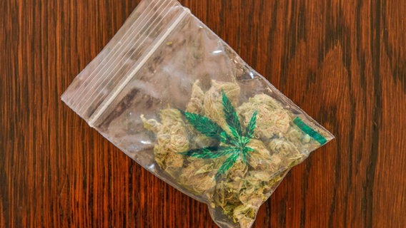 Ein Beutel mit einer Cannabis-Blüte liegt auf einem Tisch. © picture alliance / Bildagentur-online/Joko 