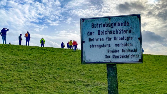 Zuschauer stehen auf einem Deich und beobachten die Überführung der "Carnival Jubilee" von der Meyer Werft in die Nordsee. © NDR Foto: Peter Becker