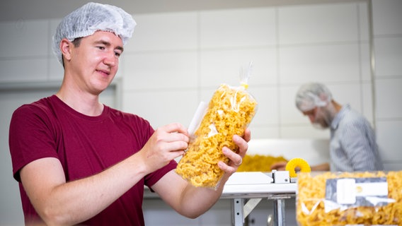 Junglandwirt Stefan Golze aus Dassel aus dem Landkreis Northeim klebt ein Etikett auf eine Verpackung. © Timo Jaworr für agrarheute Foto: Timo Jaworr für agrarheute